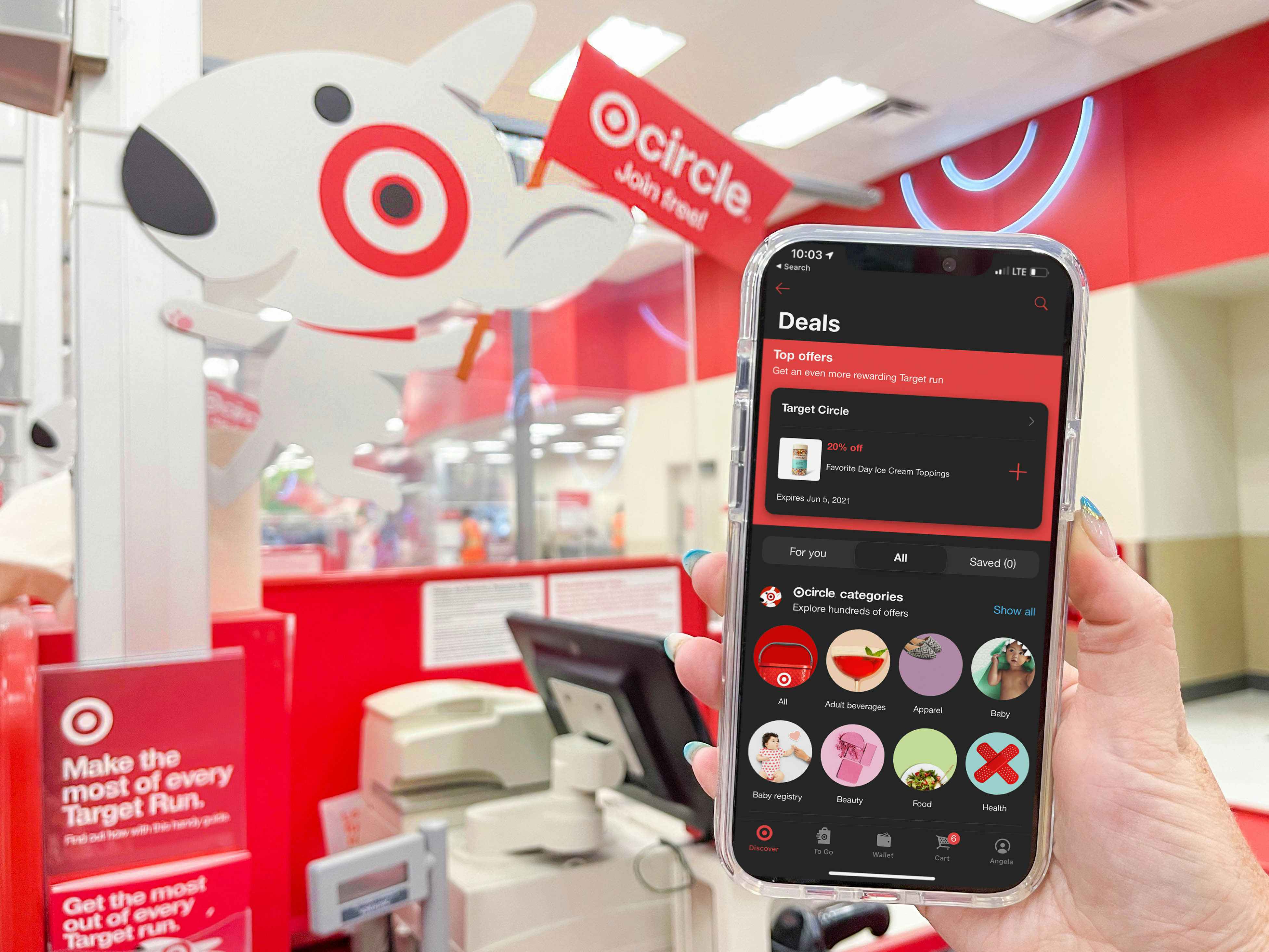 A person's hand holding a cellphone displaying the Target Circle app at the checkout lane in Target.
