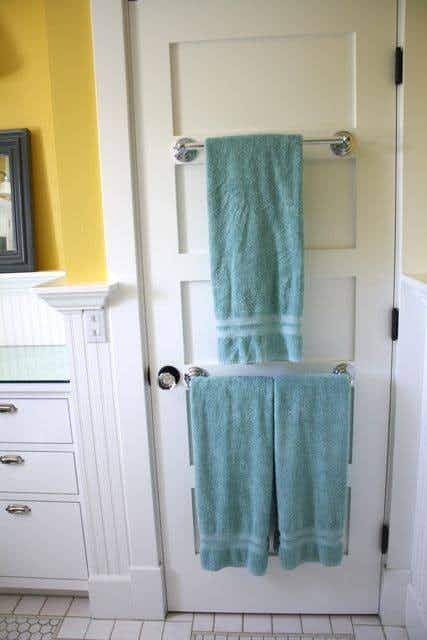 Install towel racks on the back of your door for added bathroom space. 