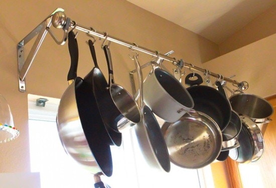 Hang a sturdy curtain rod over a window and attach pots with S hooks.