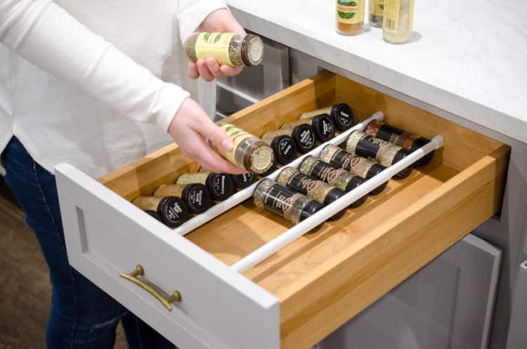Use a tension rod to organize spices in a drawer.