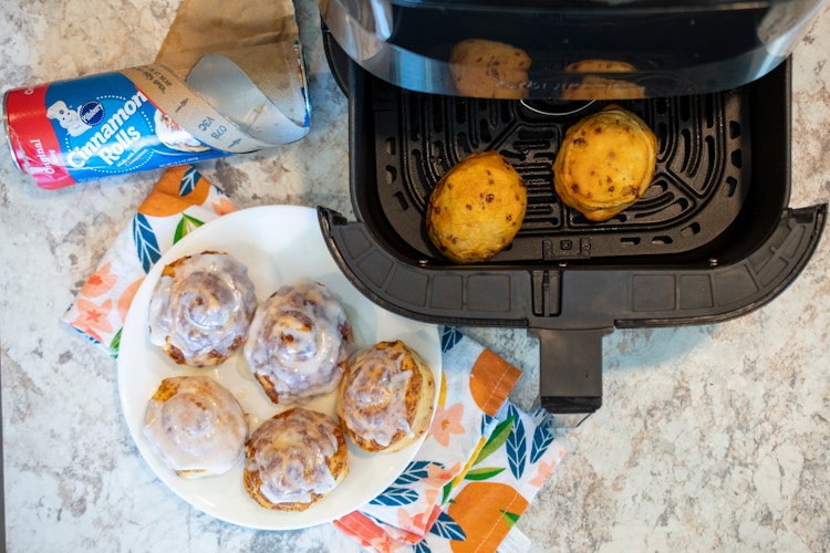 Cinnamon rolls on a plate and in an open air fryer