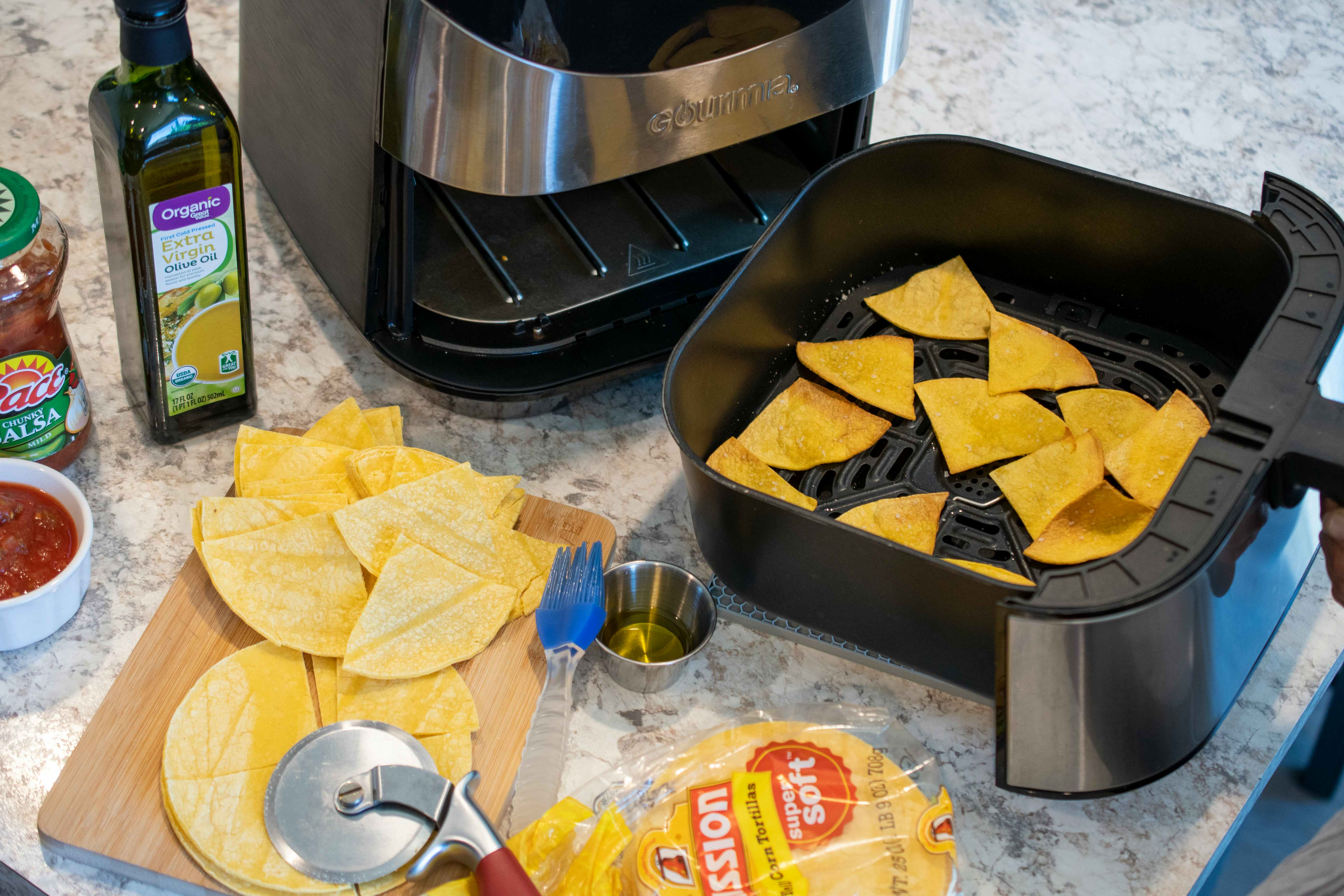 Tortilla chips being cooked in an air fryer.