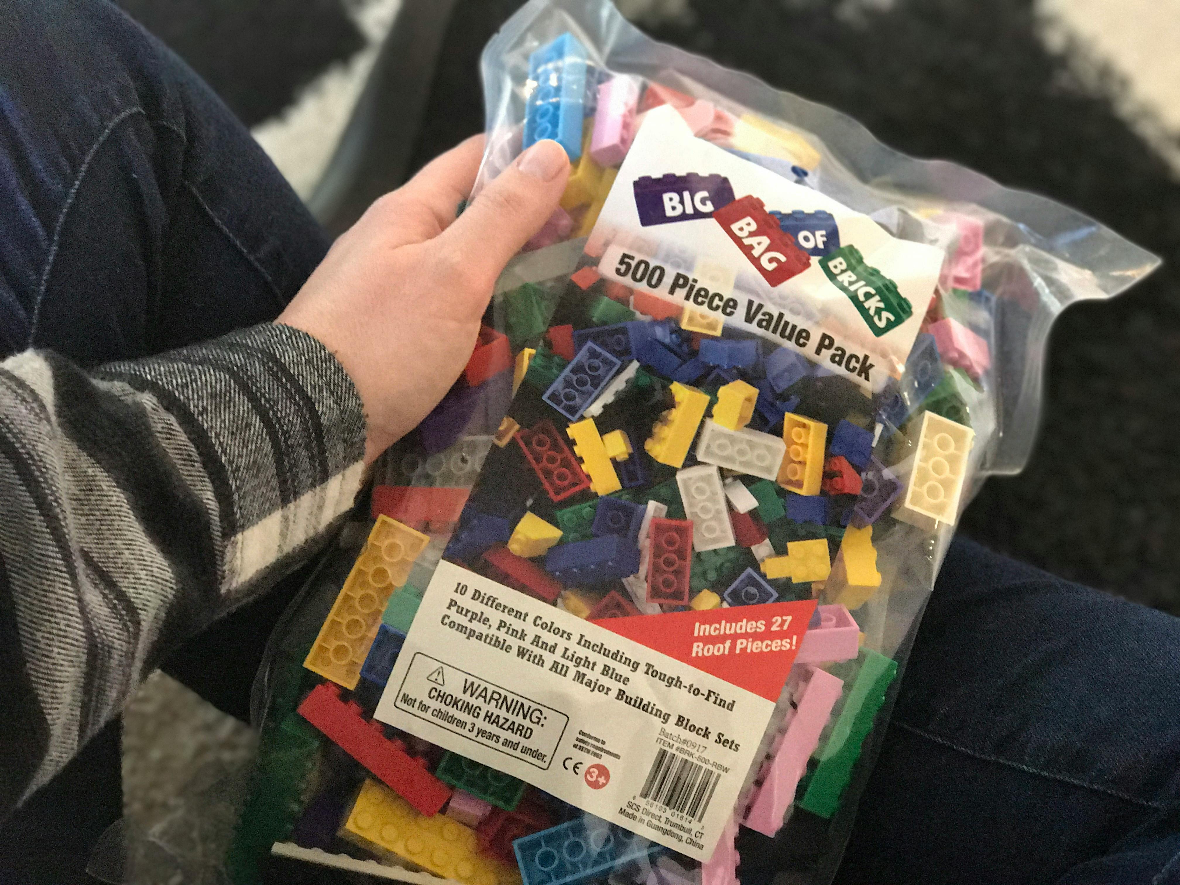 a person holding a bag of generic building blocks.
