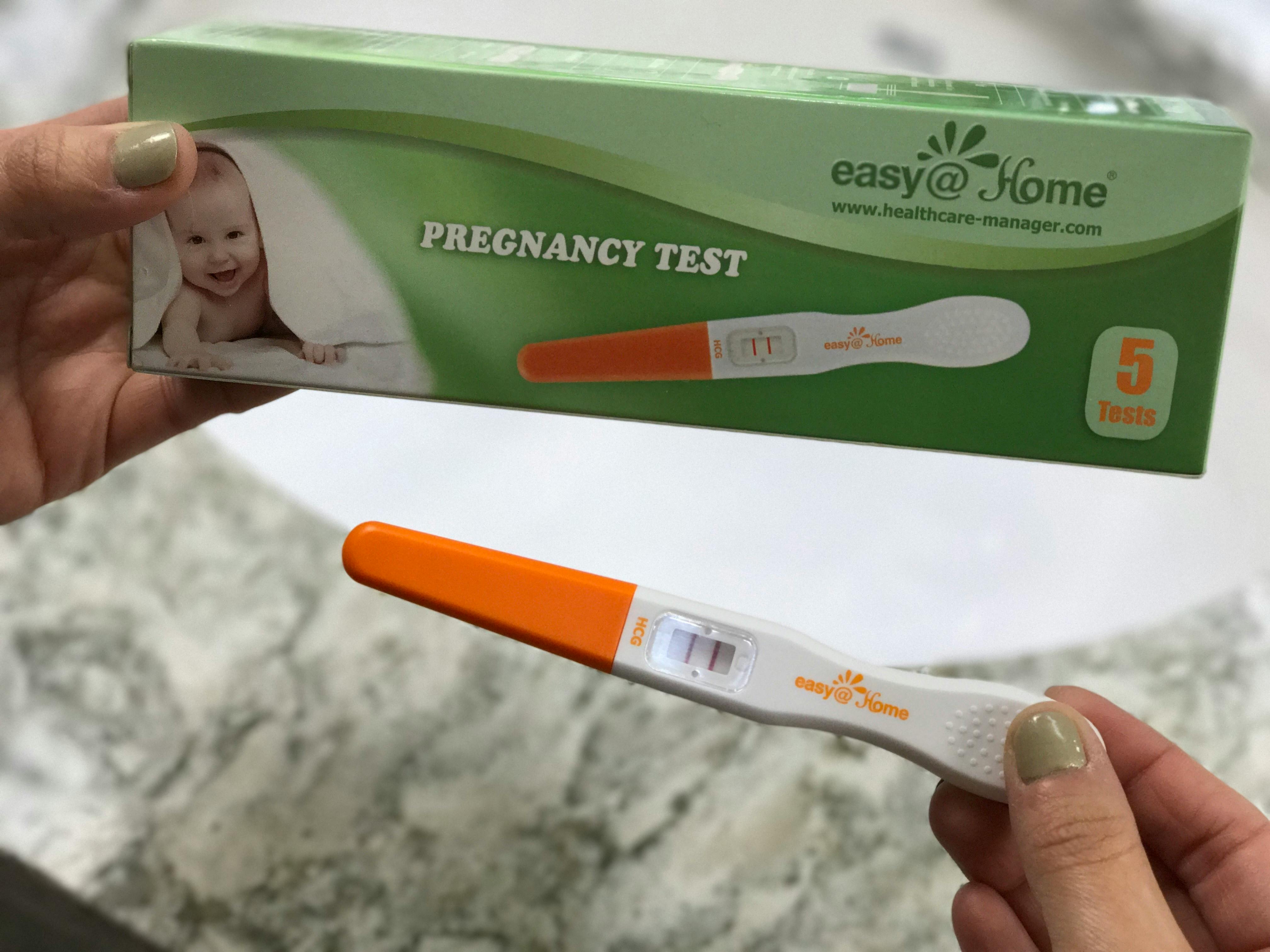 A person holding an Easy@Home pregnancy test.