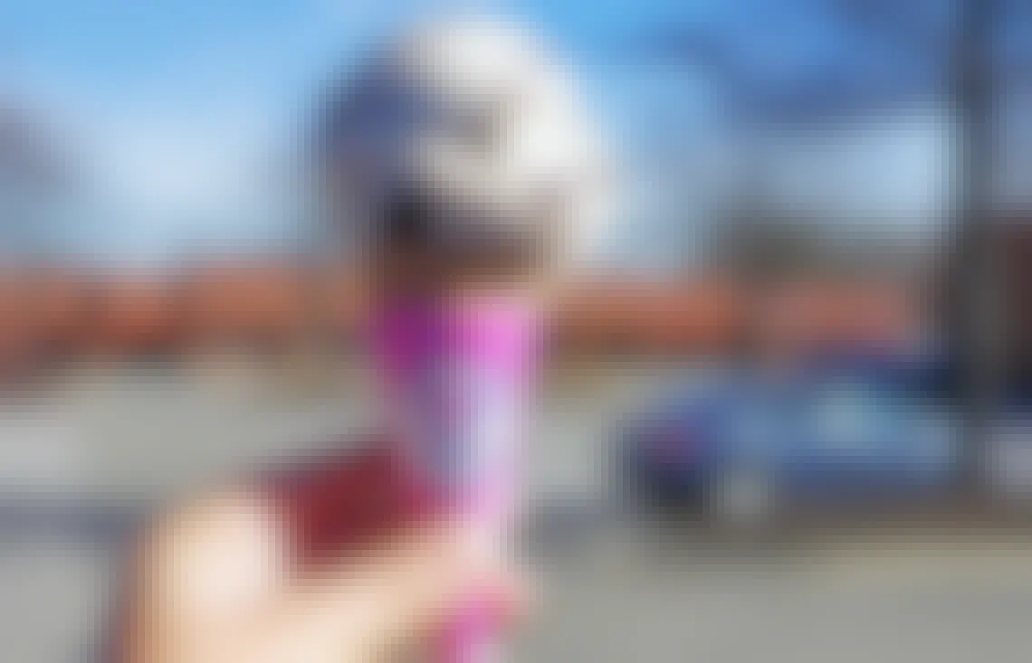 A person's hand holding up a Baskin Robbins ice cream cone.