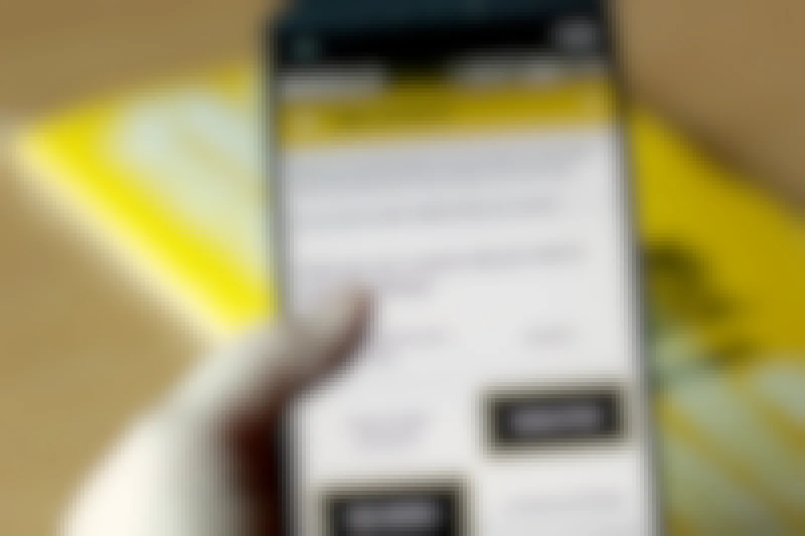 A person holding their phone center-frame with the Buffalo Wild Wings app open to a survey used to gauge the user's interests. The survey requests, 