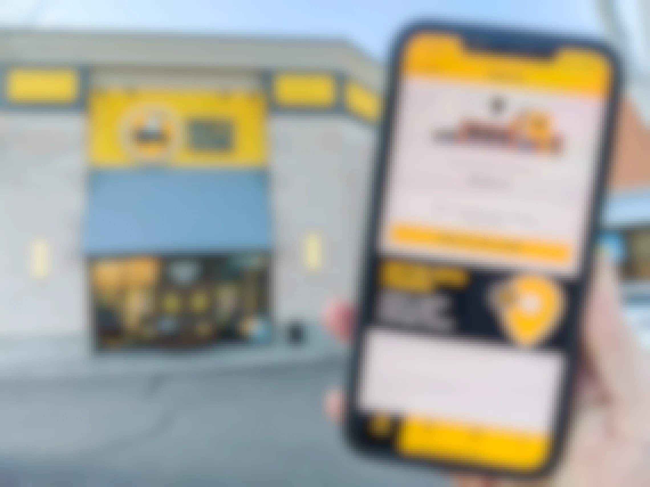 A person holding their iPhone up showing the check-in page of the Buffalo Wild Wings mobile app in front of a Buffalo Wild Wings storefront.