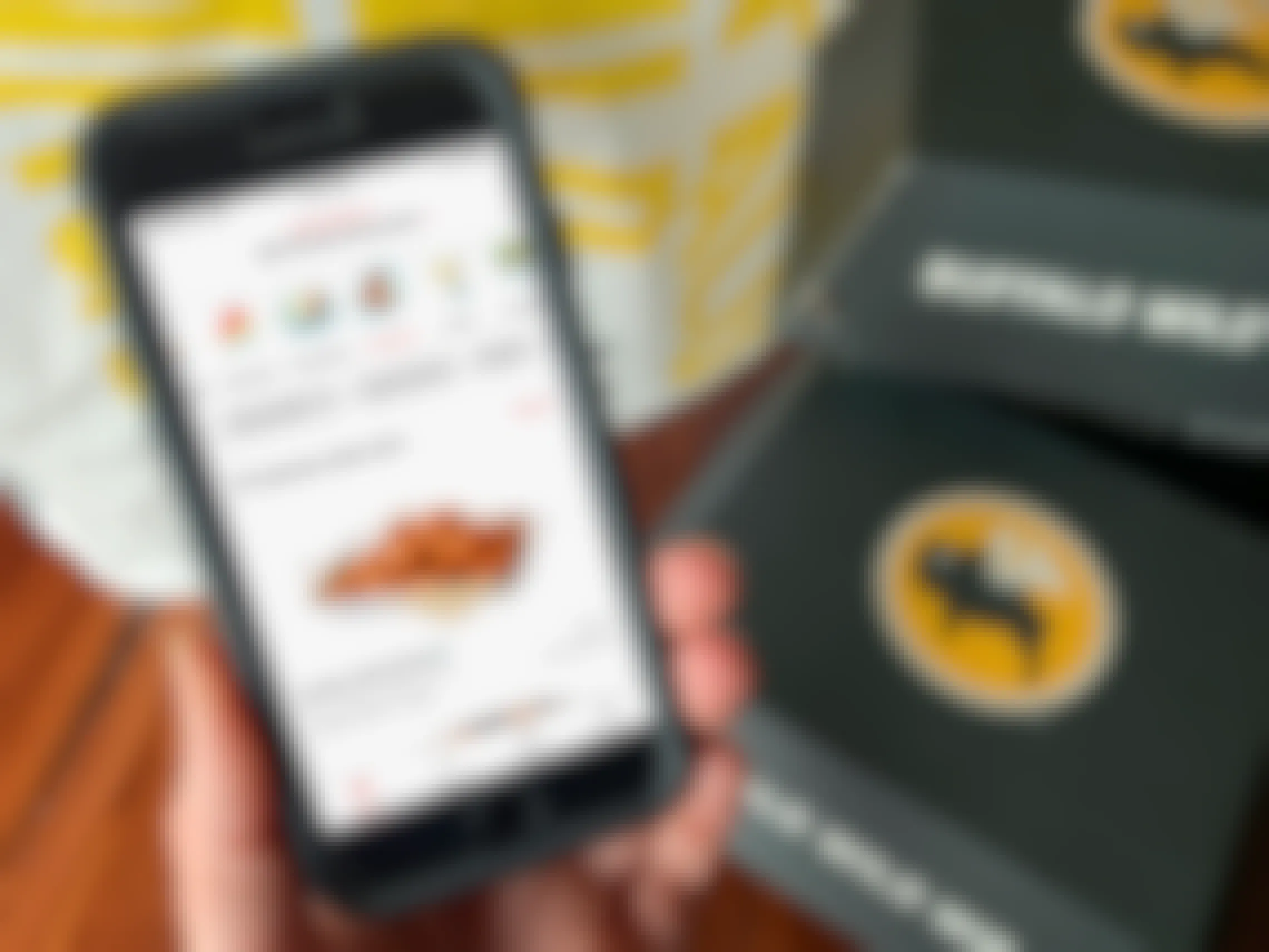 The DoorDash app displaying the Buffalo Wild Wings order page next to to go boxes and a delivery bag.