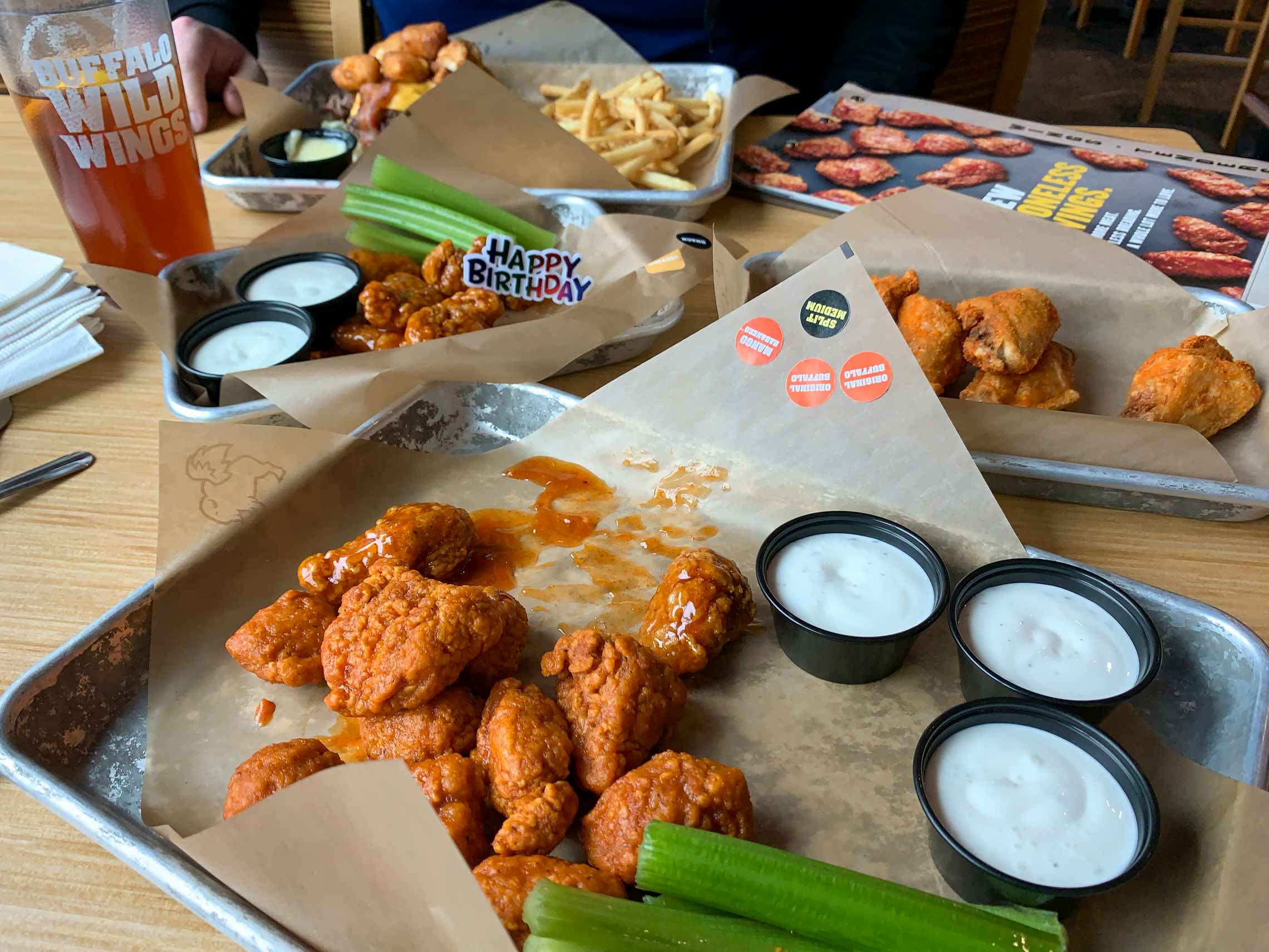 Wings and fountain drinks on a table in a Buffalo Wild Wings restaurant.
