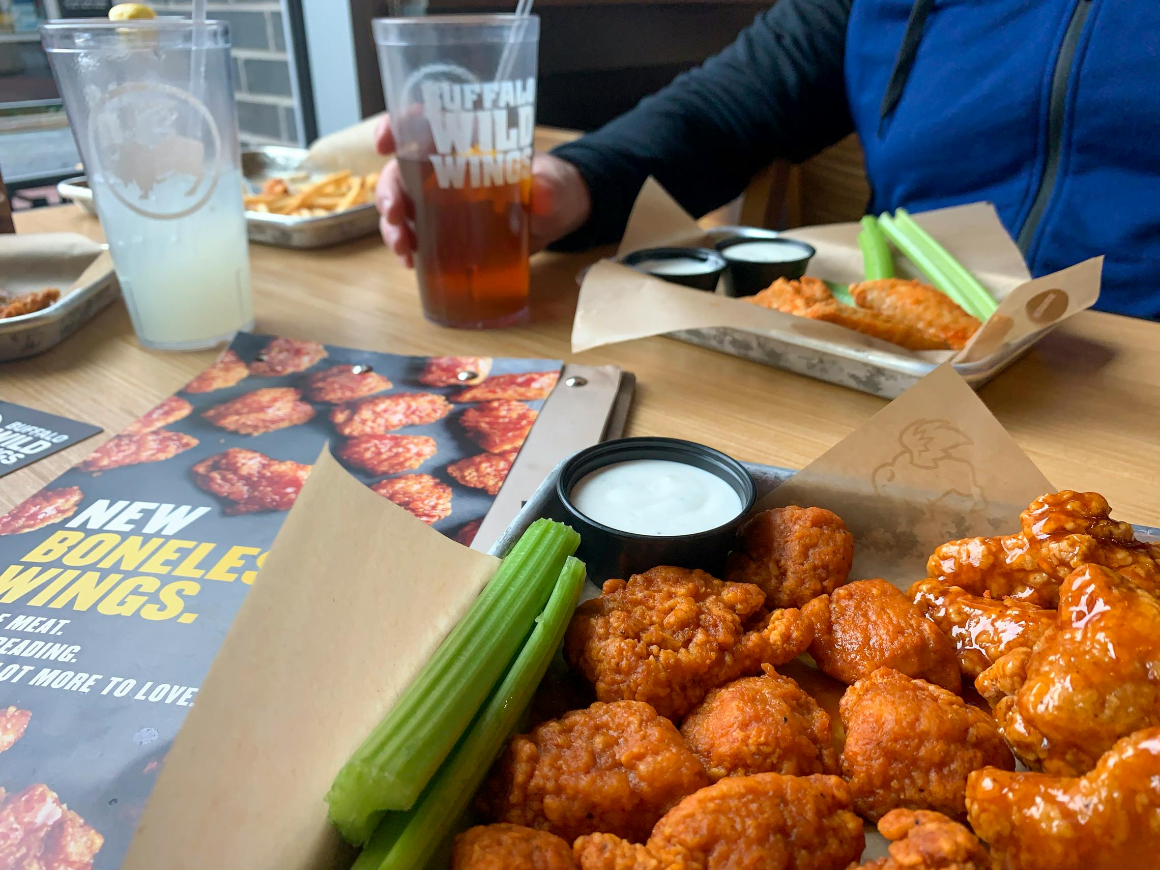 Wings and fountain drinks on a table in a Buffalo Wild Wings restaurant.