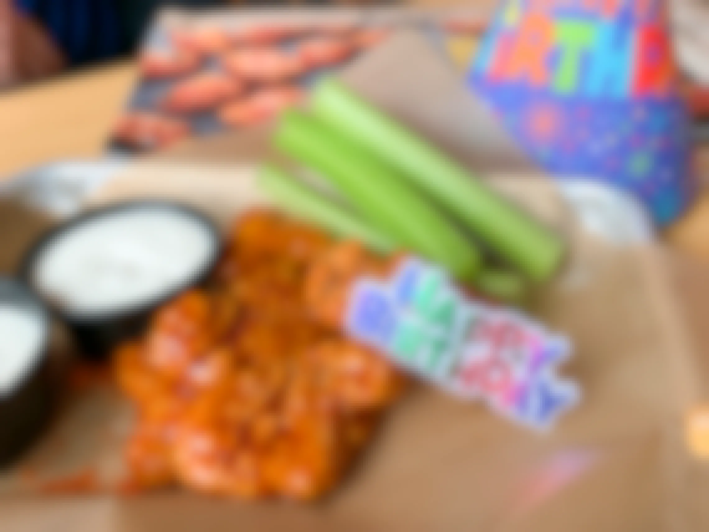 A free Birthday snack size plater of boneless buffalo wings with a plastic Happy Birthday tag on top of it and a party hat on the table behind it.