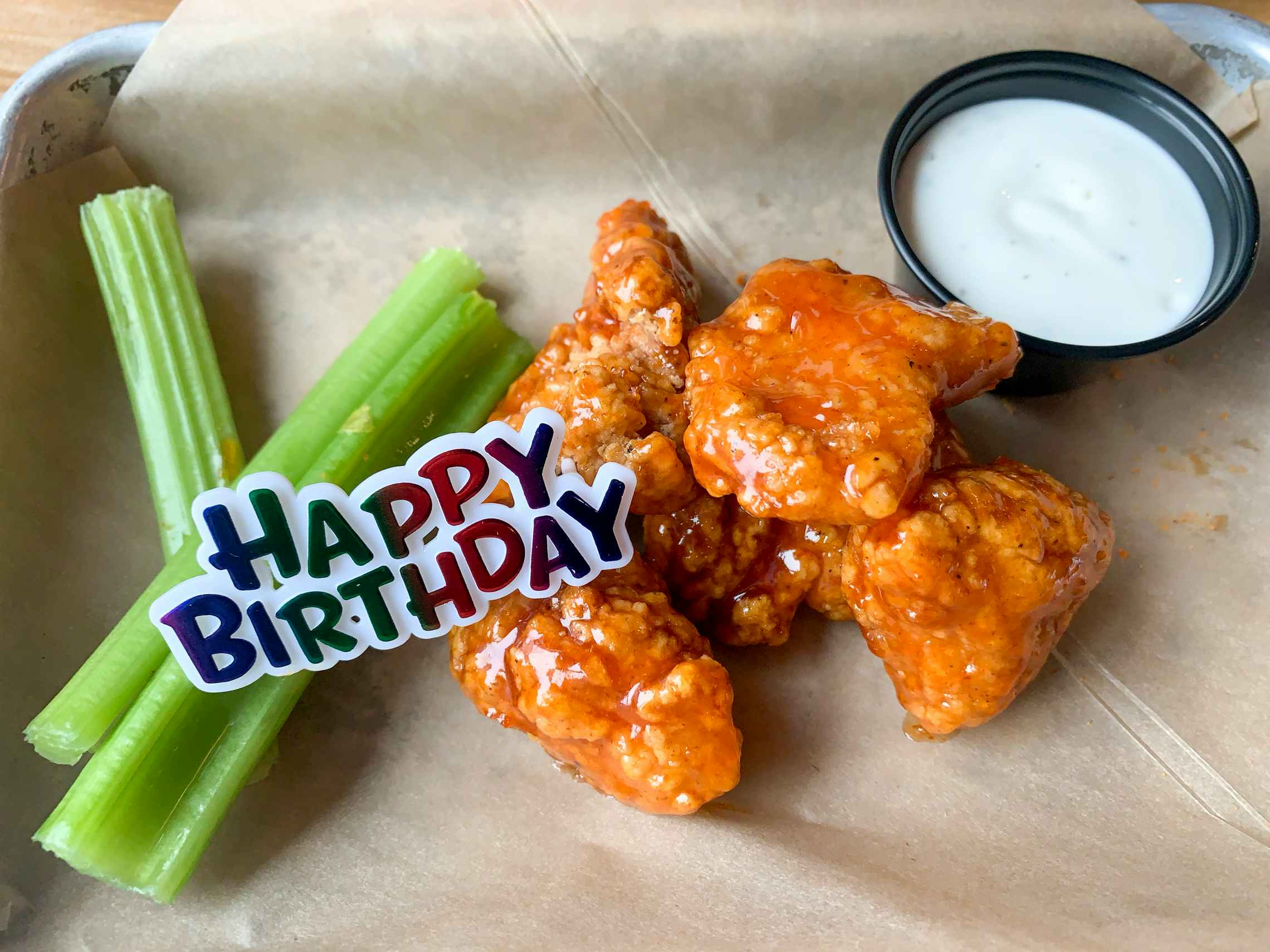 A free Birthday snack size plater of boneless buffalo wings with a plastic Happy Birthday tag on top of it.