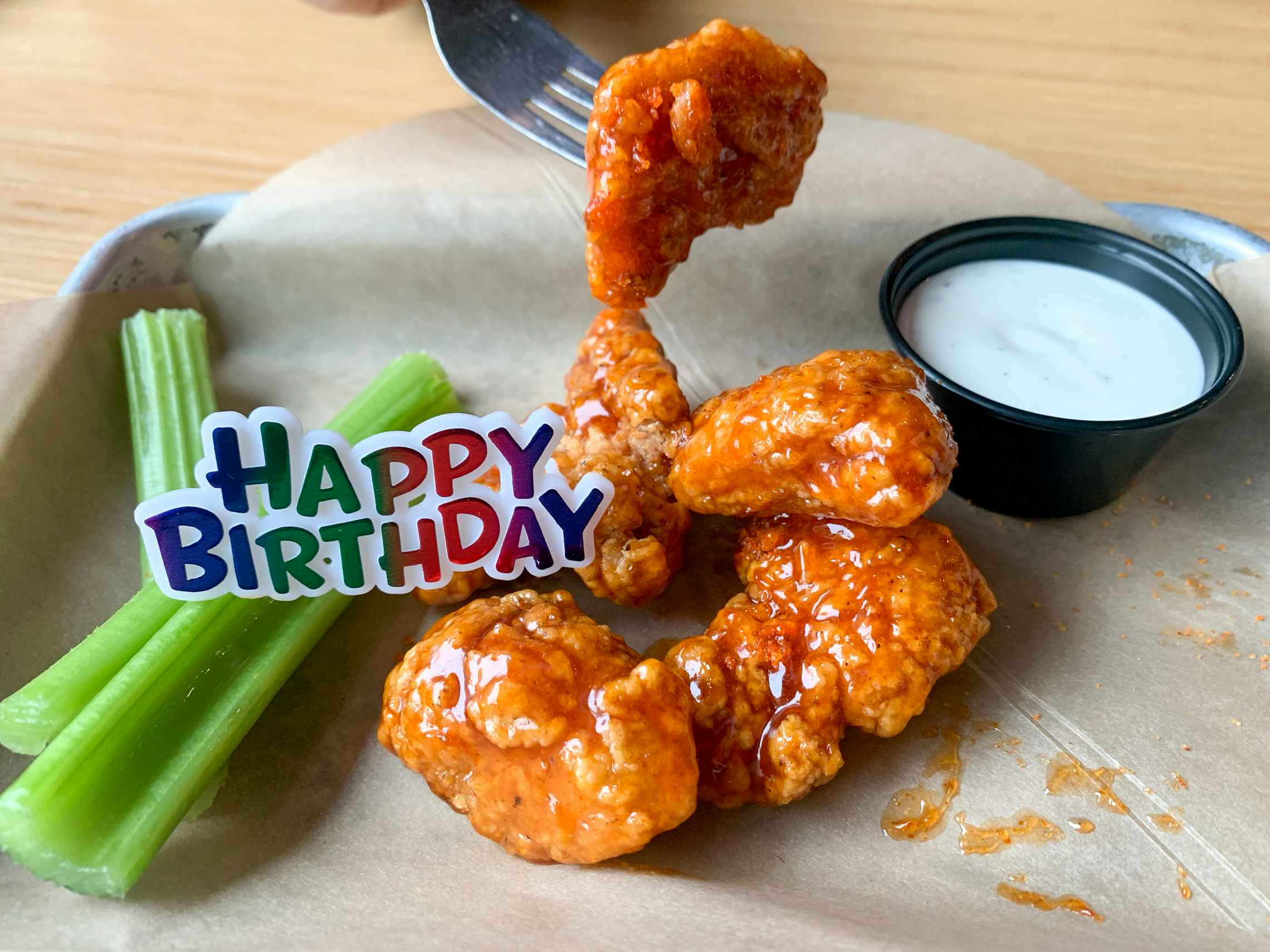 A free fast food Birthday snack size plater of boneless buffalo wings with a plastic Happy Birthday tag on top of it.