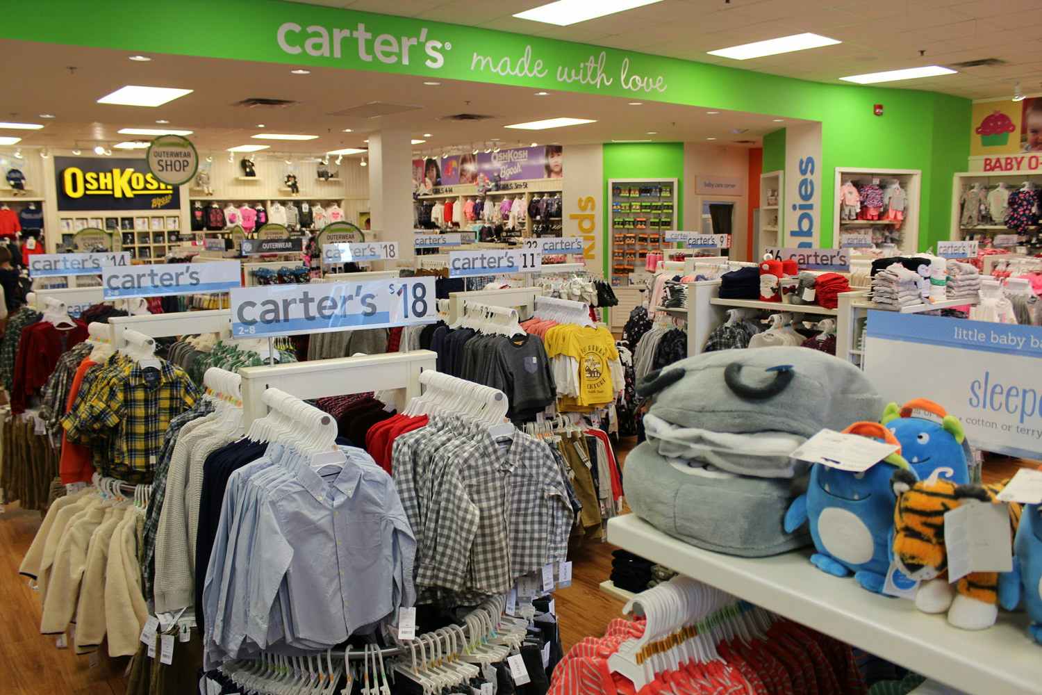 A Carter's oulet store with children's clothing on racks and shelves.