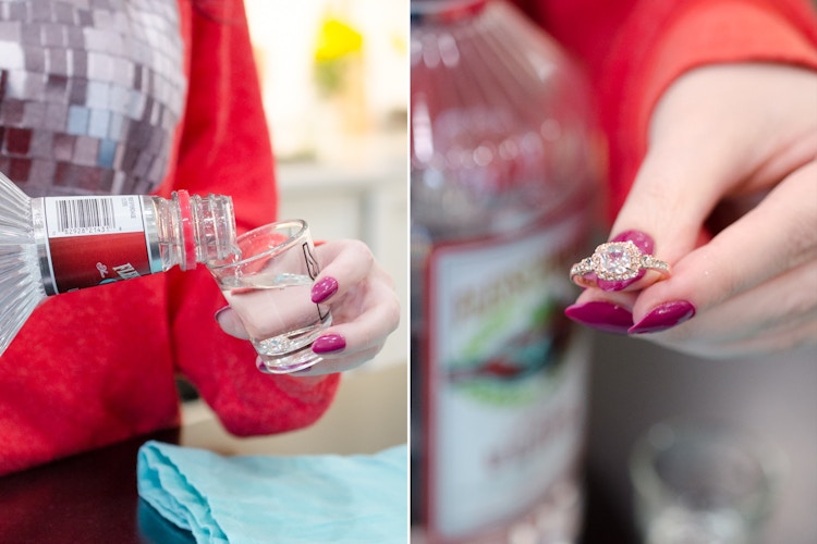 Person pouring vodka into a shot class with a ring inside