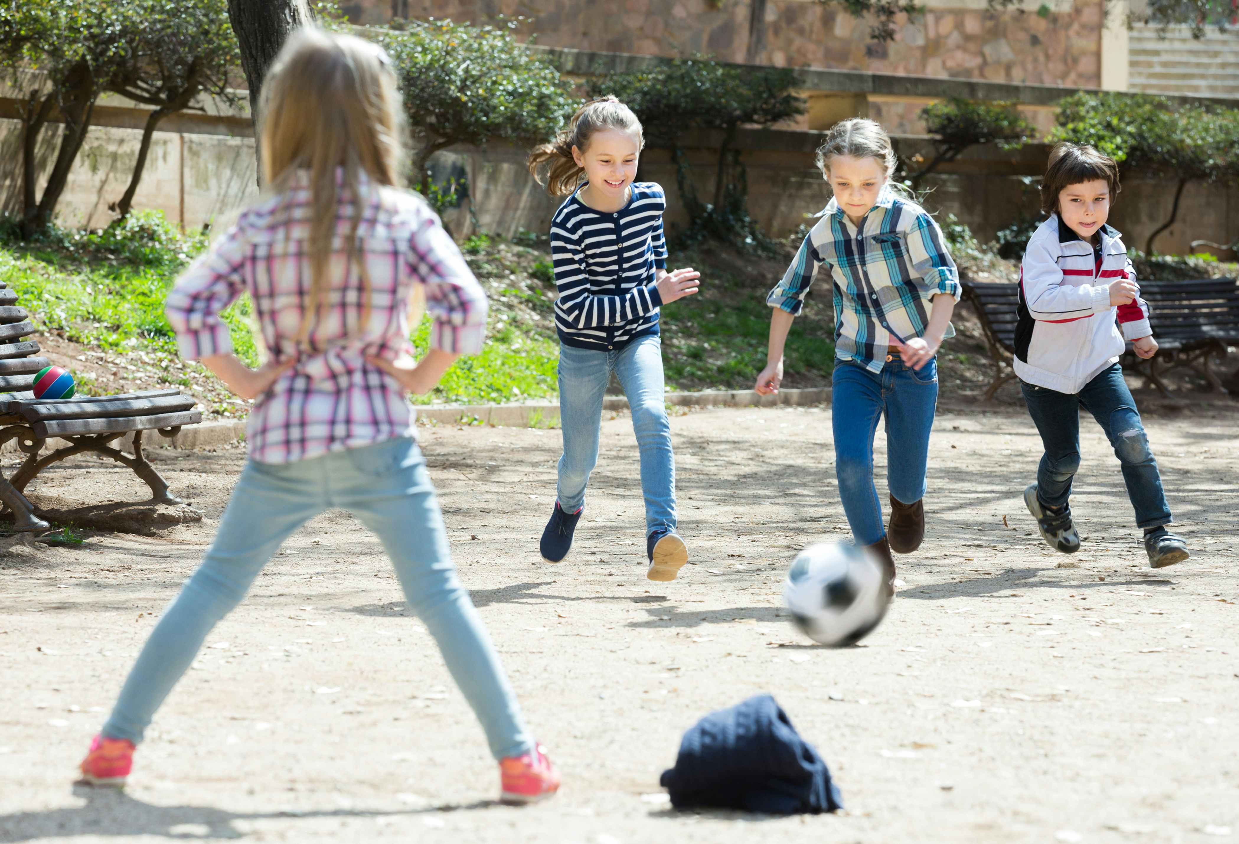 Kids playing with a soccer ball in a park