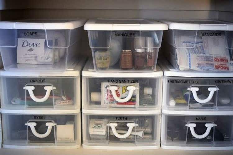 Stack plastic storage bins and fill them up with small essential items.