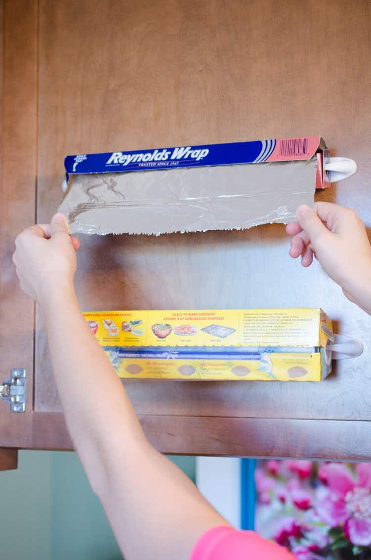 make rolls of foil and plastic wrap easily accessible on the inside of your cabinet.