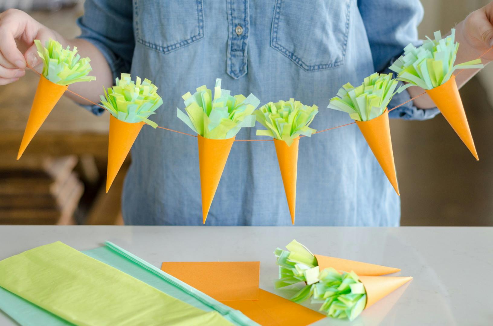 Create a carrot garland with cardstock and tissue paper.