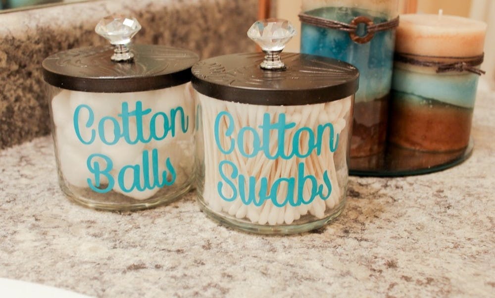 Store bathroom supplies like cotton balls or Q-Tips in old candle jars.