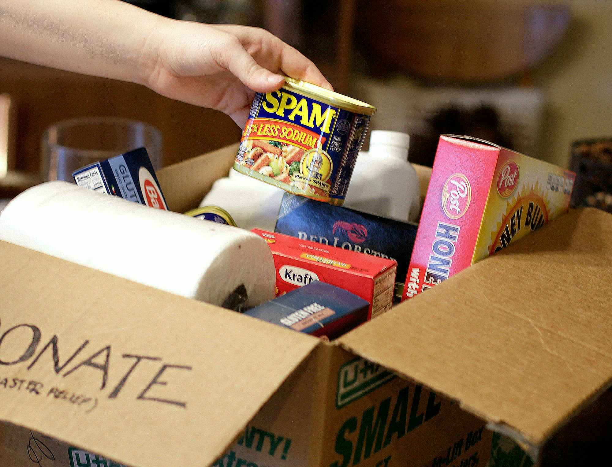a person putting food into a donate box 