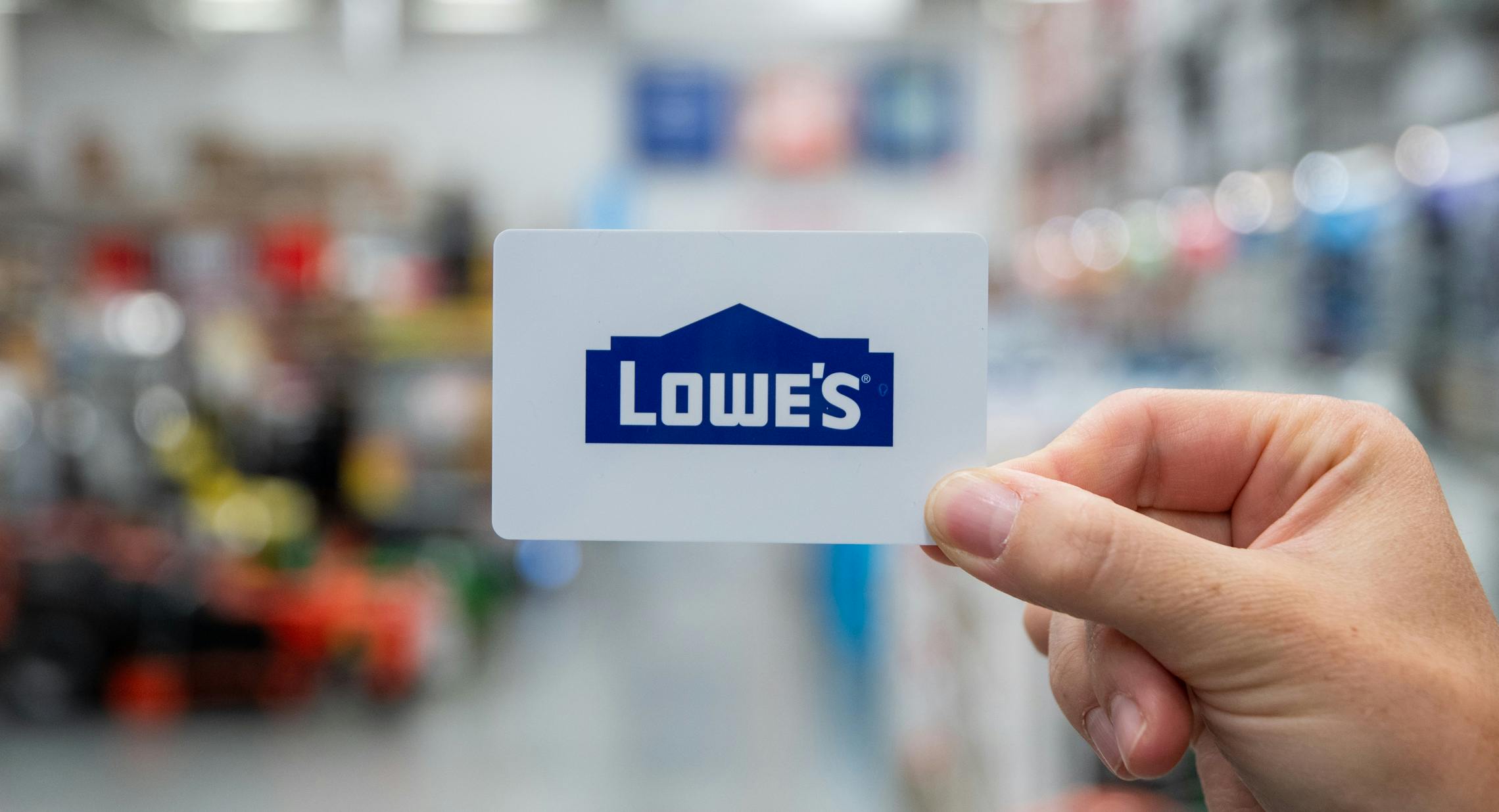 A person holding a gift card inside Lowes.