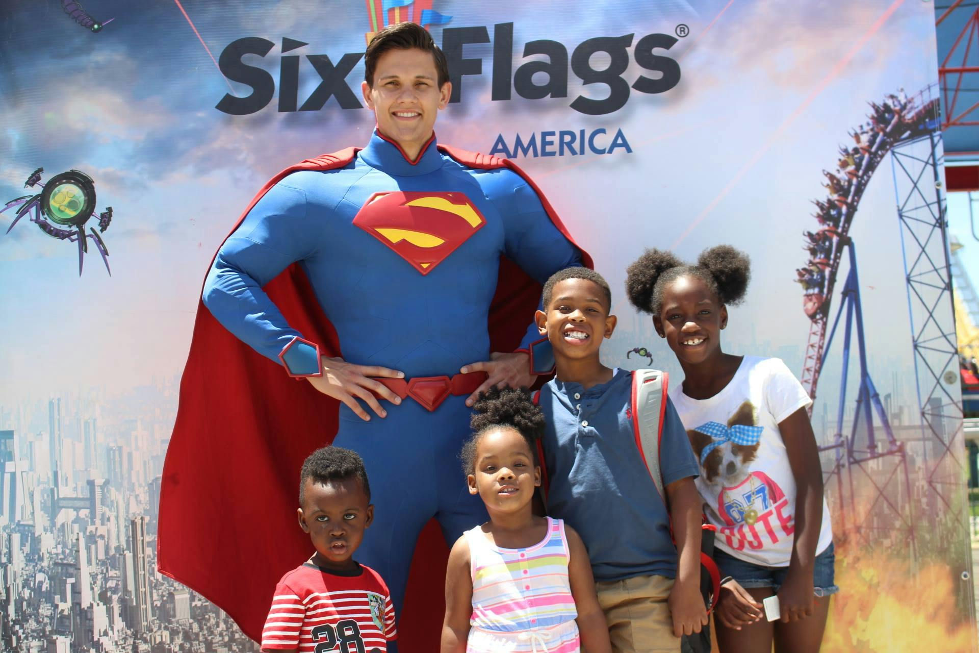 For children posing for a photo with a man dressed as superman at six flags America amusement park