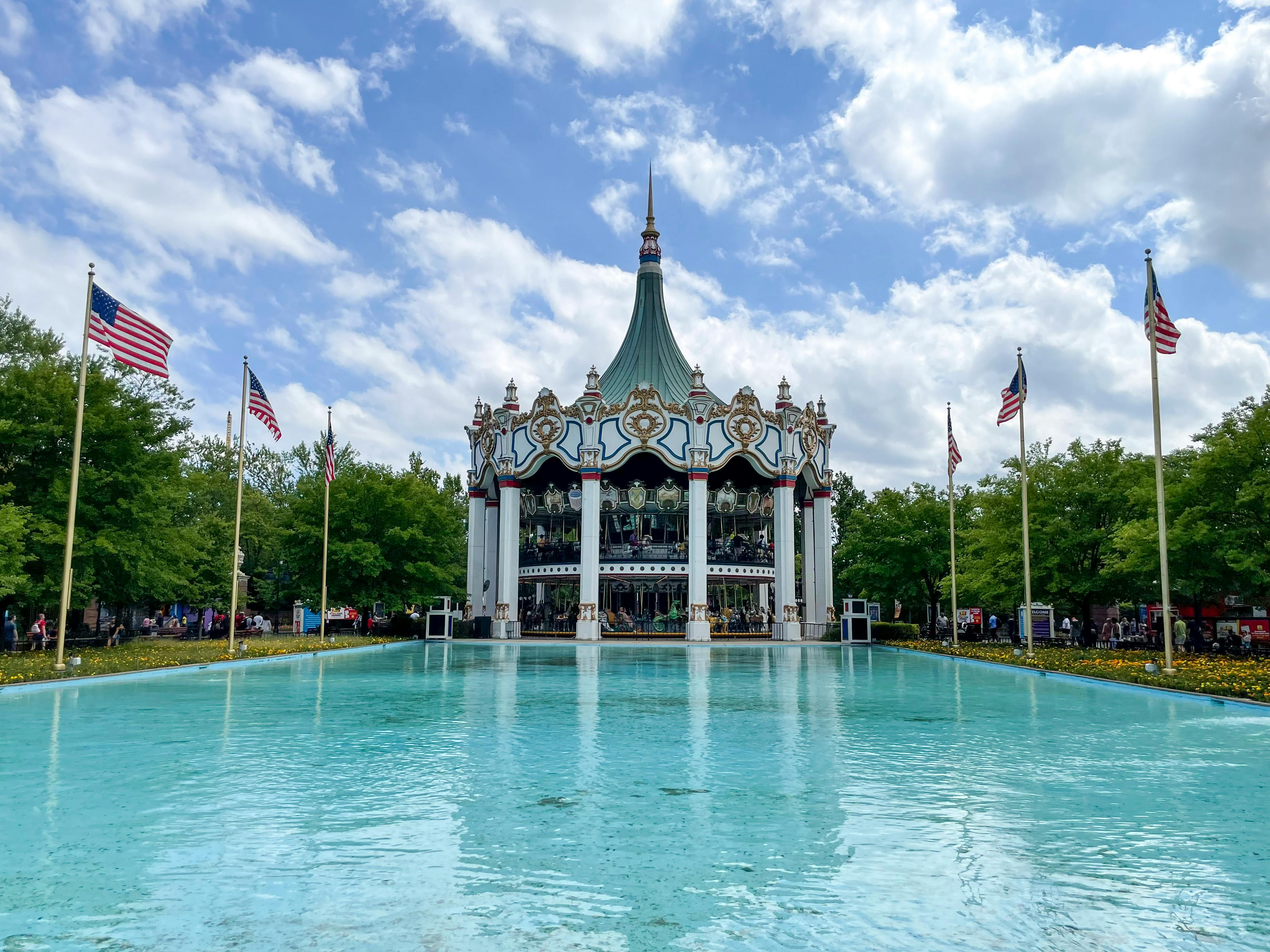 A reflective pool in front of a carousel ride