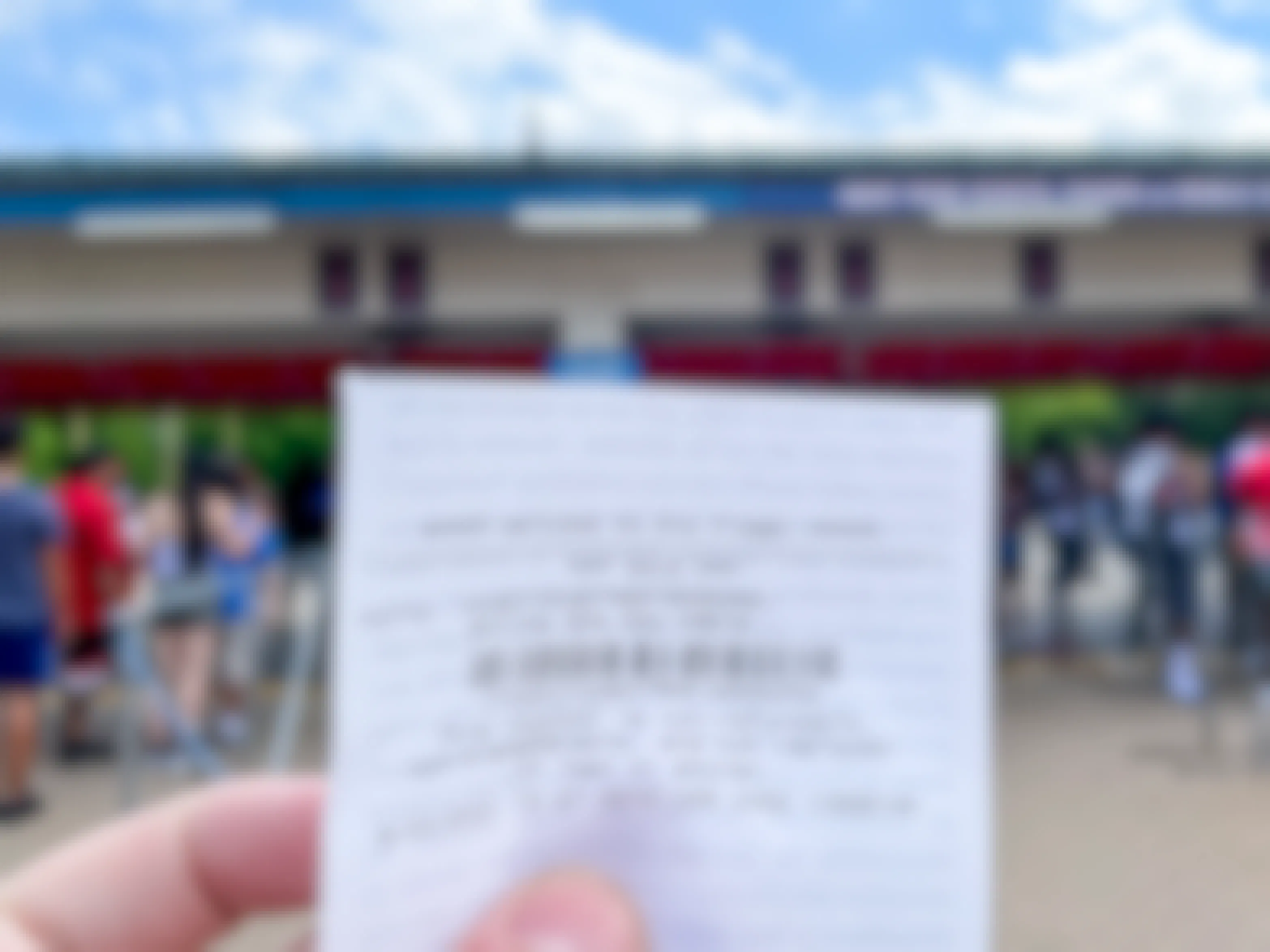 A Six Flags ticket held in front of the amusement park entrance