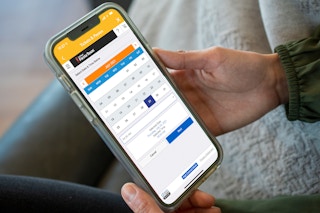 A person selecting a date on the SixFlags app.