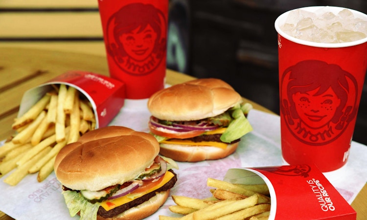 two burgers two fries and two sodas on table 