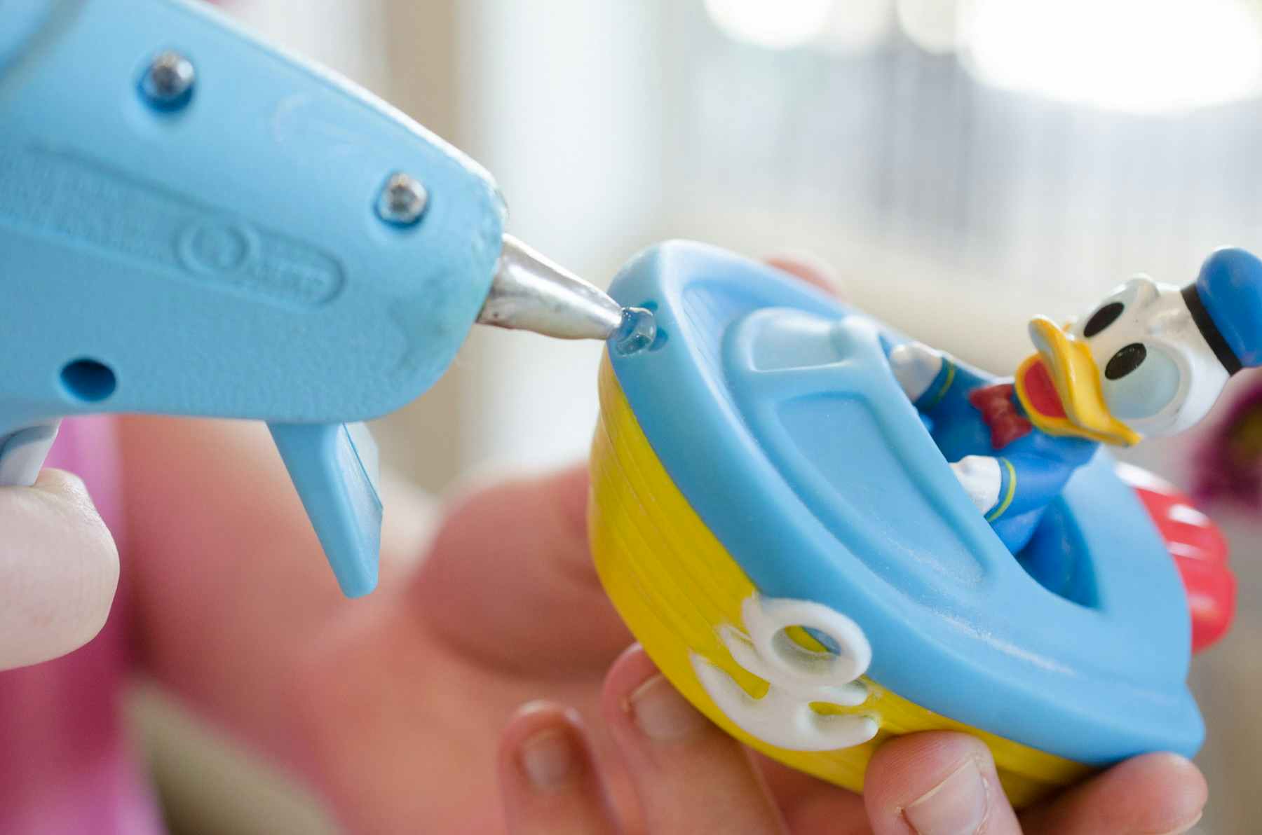 someone putting hot glue in a kids toy