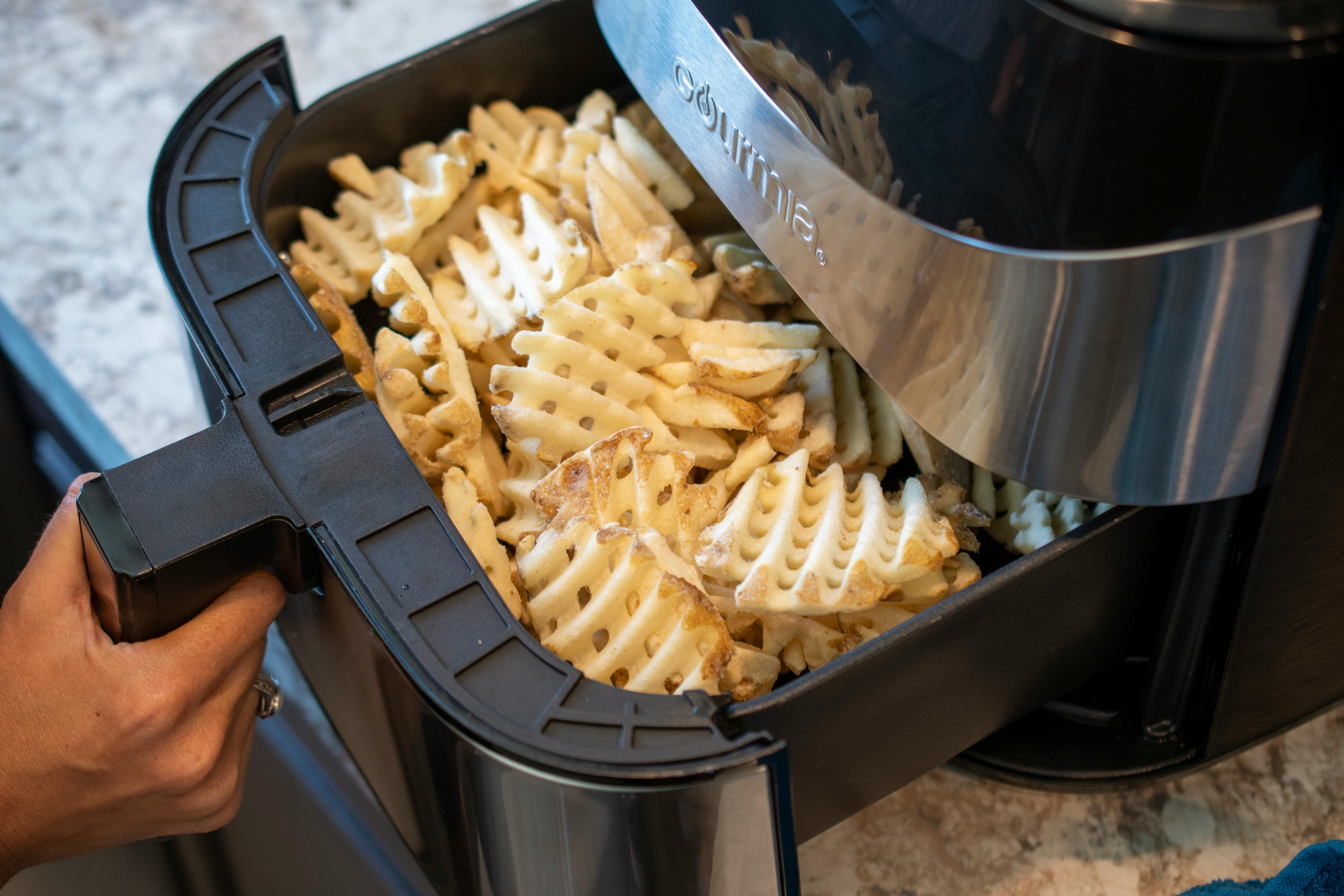 An air fryer packed with waffle french fries 