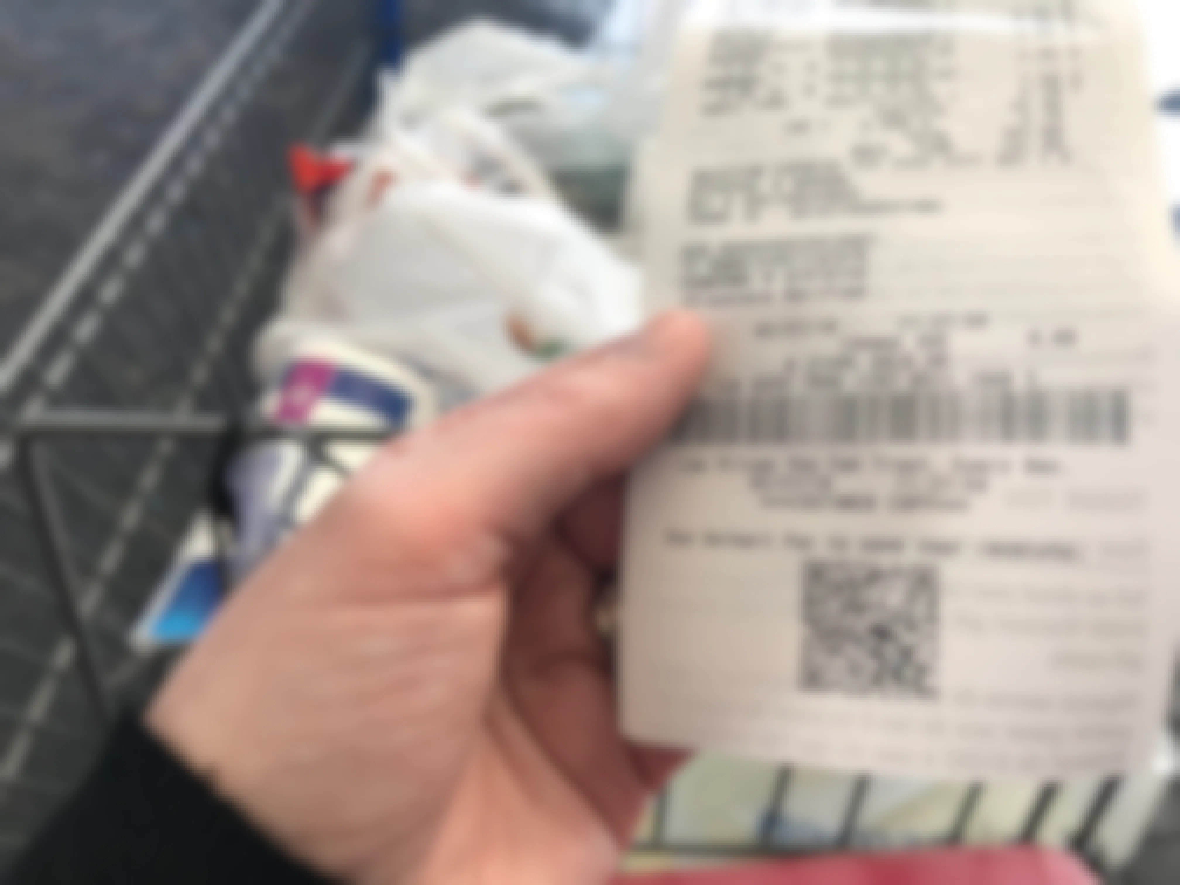 person holding walmart receipt near cart of bagged purchased items