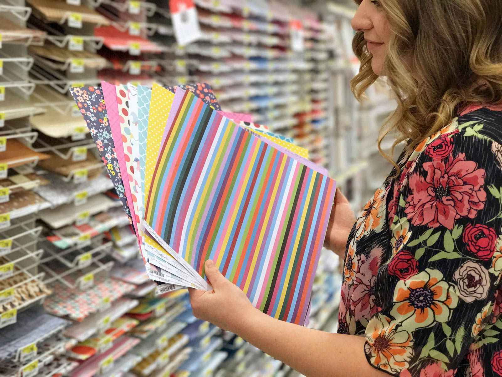 A woman looking at scrapbooking materials at a craft store.