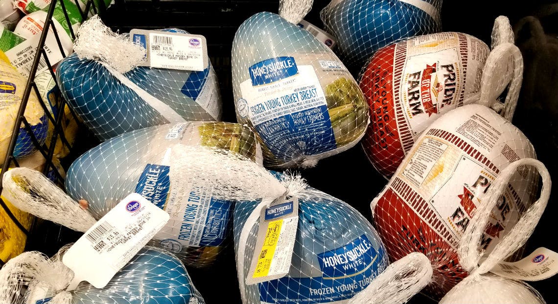 Frozen turkeys stacked in a store display.