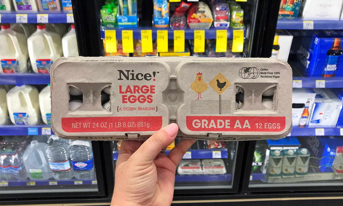 A person holding a carton of Nice! brand eggs.