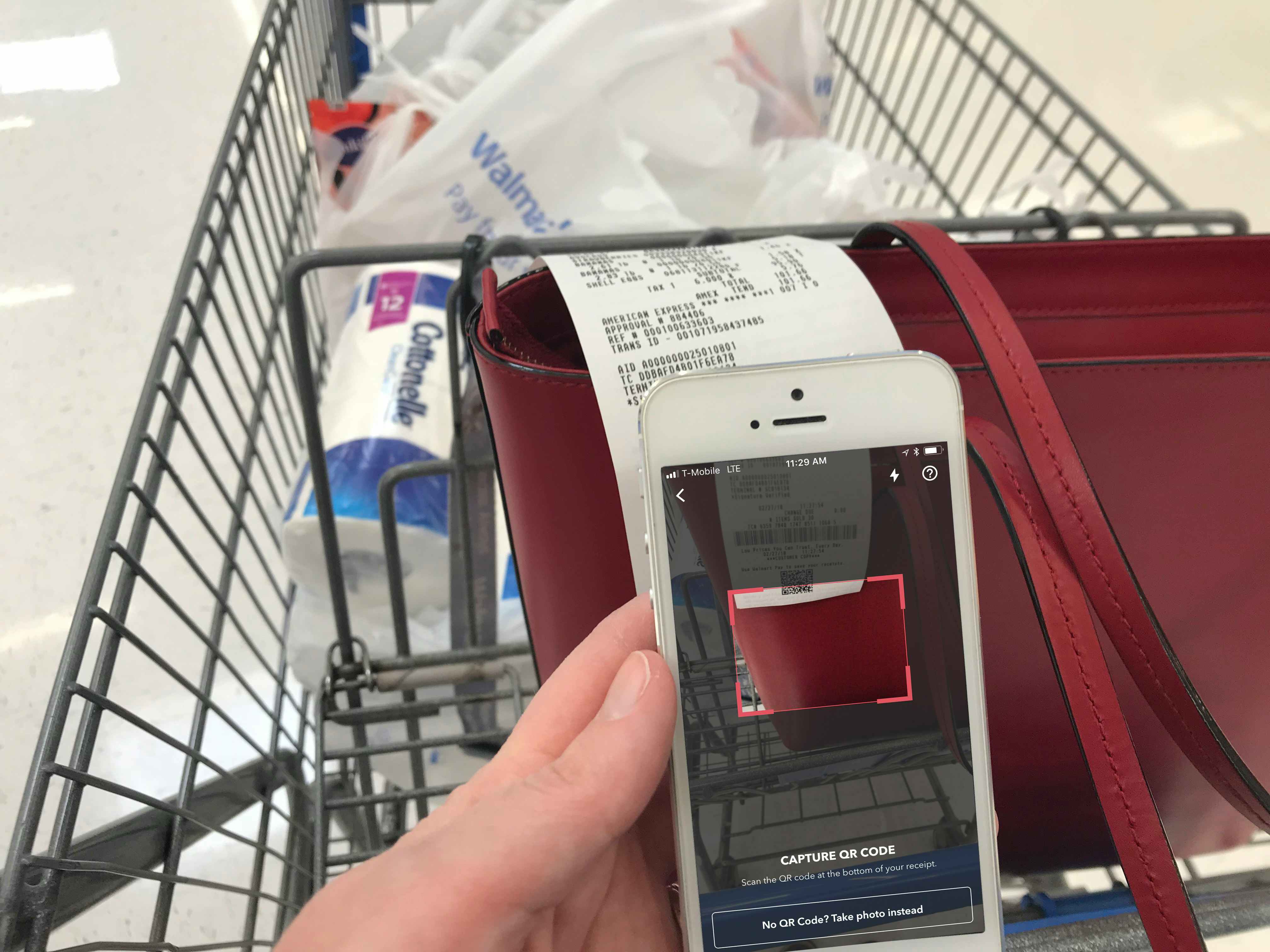 person with cart scanning walmart qr code on receipt for ibotta app