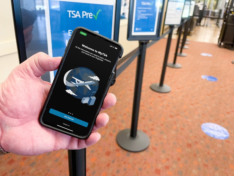 man holding cellphone with tsa app at tsa line