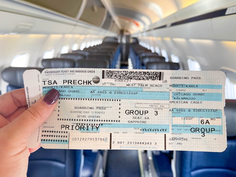 woman holding airplane ticket on empty airplane.