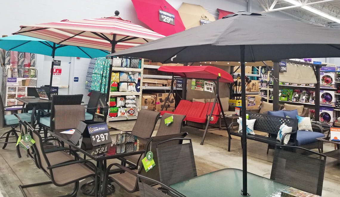 patio center at walmart filled with patio dining sets, colorful umbrellas, pillows and other outdoor essentials