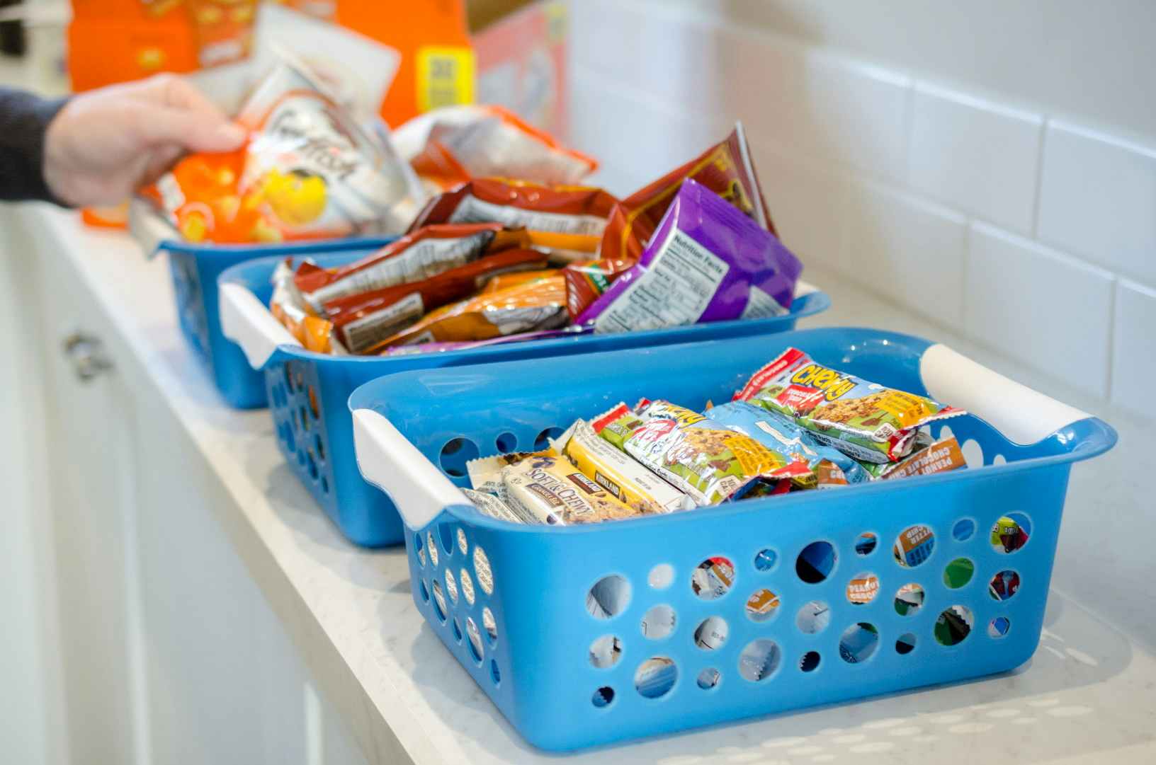 plastic baskets lined up on a counter with different snacks inside 