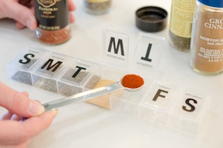 and person adding spices into a pill holder