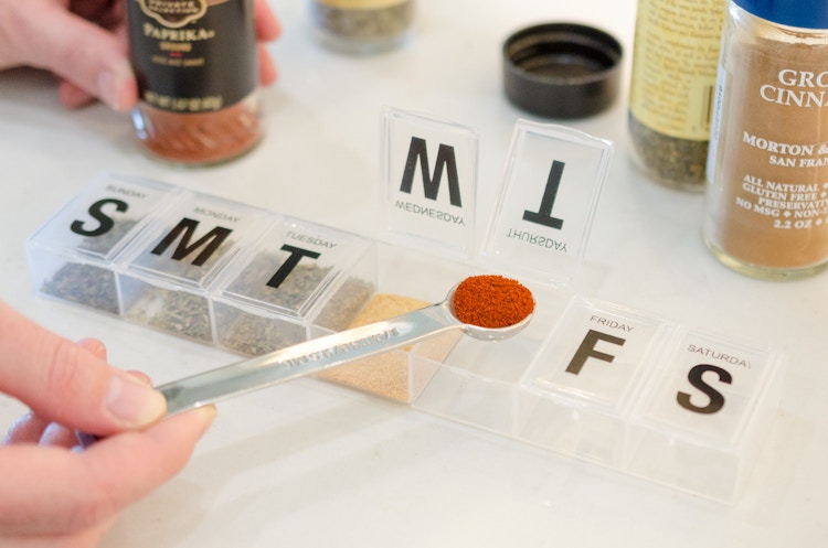 and person adding spices into a pill holder 
