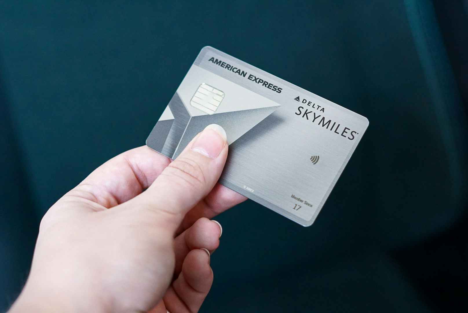 someone holding up their American Express Delta Skymiles credit card