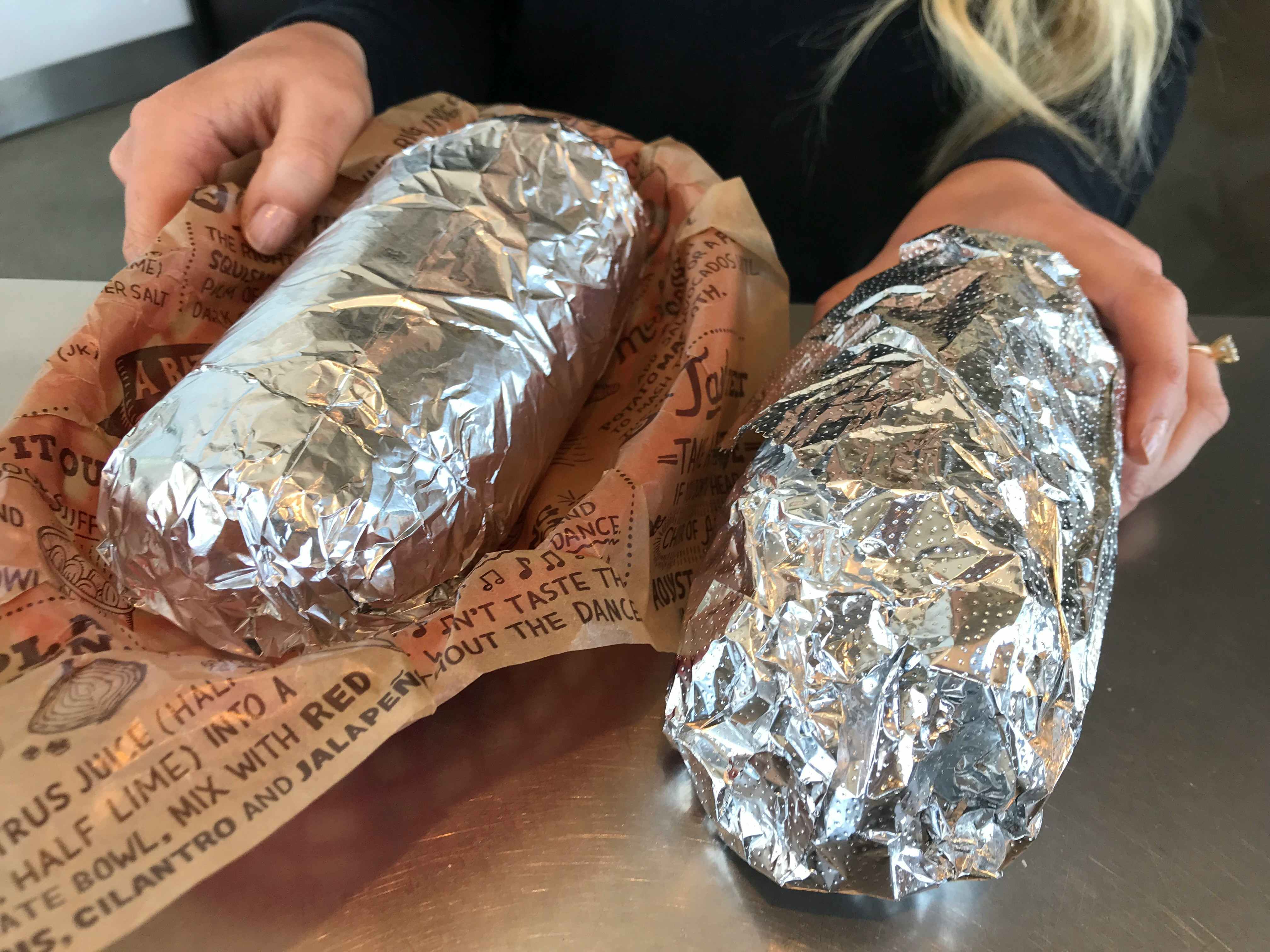 two chipotle burritos on a table 