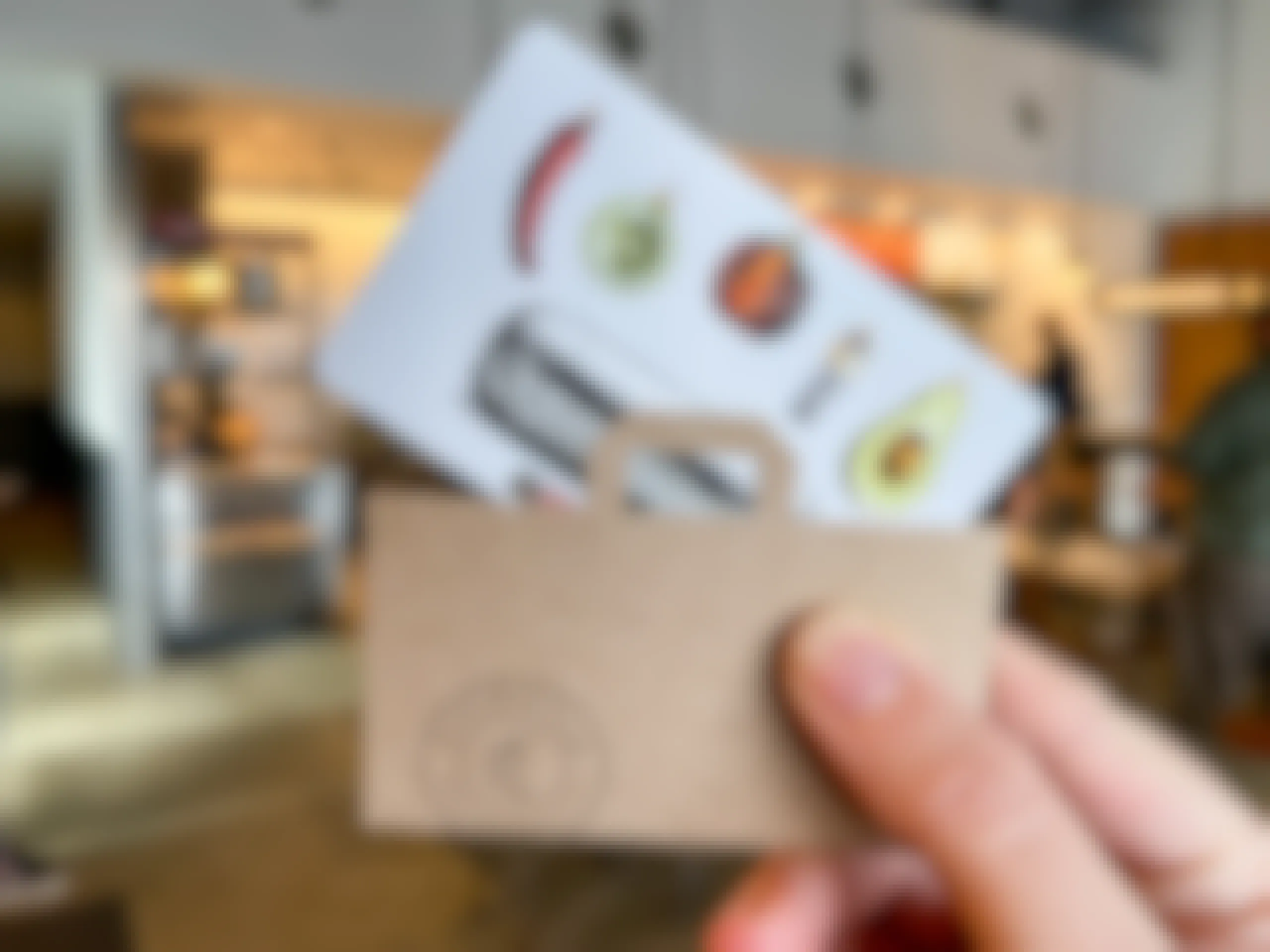someone holding chipotle gift card inside a Chipotle.