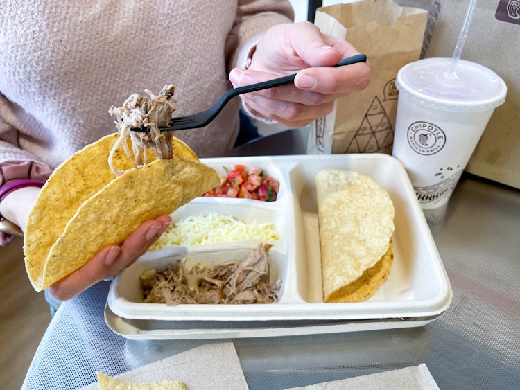 someone filling taco above kids meal
