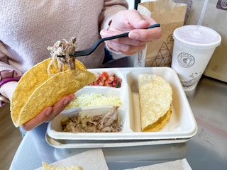 someone filling taco in kids meal