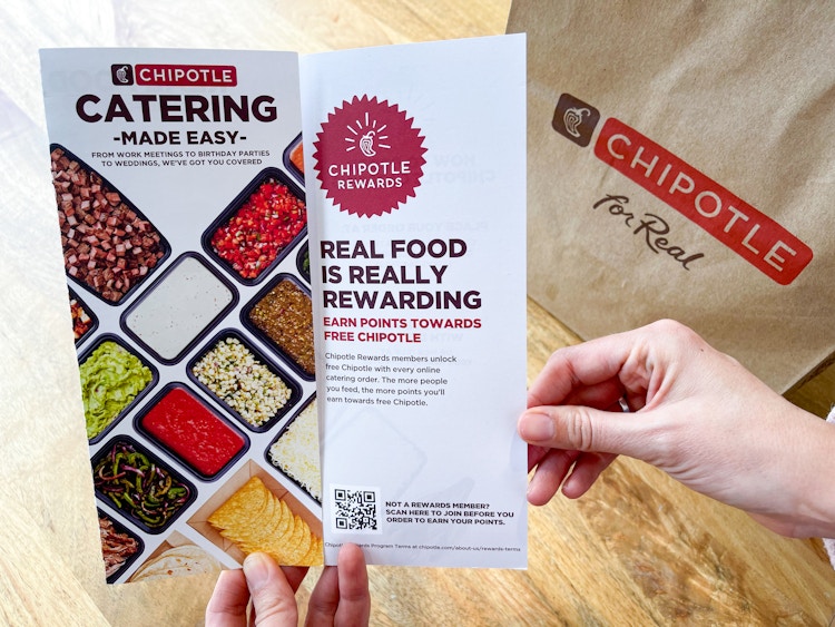 someone holding chipotle rewards pamphlet